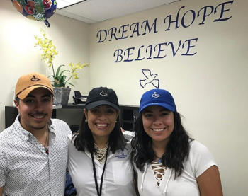 family of occupational therapy graduates from Keiser University at Dream, Hope & Believe Therapy, smiling at the camera