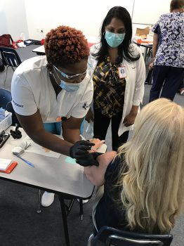 Keiser University Nursing Student Mirline Torchin Prepares To Administer A Vaccine Under The Guidance Of Dr Maureen Harry - Keiser University’s Port St. Lucie Campus Hosts Vaccine Clinic - Community News Keiser University Nursing Student Mirline Torchin prepares to administer a vaccine under the guidance of Dr. Maureen Harry