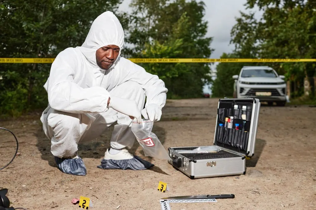 Male forensic scientist working on crime scene.