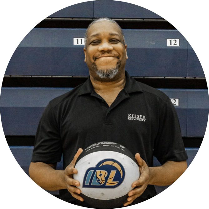 Justin Harmon of Keiser University Sports Management Justin Harmon of Keiser University Sports Management poses with a ball in front of the bleachers.